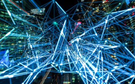 Dynamic urban scene showcasing interconnected light trails representing digital communication networks.