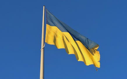 Vibrant Ukrainian flag waving under a clear blue sky, symbolizing national pride.