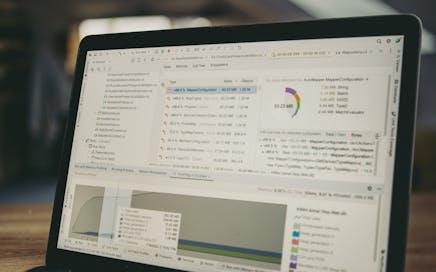 A close-up view of a laptop screen showing a coding and data analysis software interface in an indoor setting.