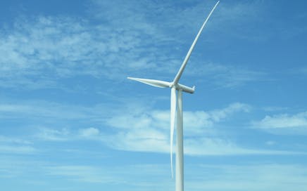 A wind turbine under a clear blue sky in Bo-Karoo, promoting renewable energy solutions.
