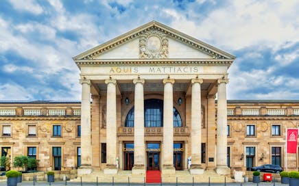 Stunning frontal view of the historic Kurhaus in Wiesbaden, Germany under a dramatic sky.